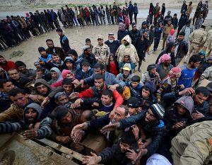 Displaced Iraqi people, who fled their homes, try to receive aid from security forces during a battle between Iraqi forces and Islamic State militants, near Badush, Iraq, March 16, 2017. REUTERS/Stringer EDITORIAL USE ONLY. NO RESALES. NO ARCHIVE.