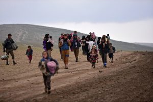 Displaced Iraqi people, who fled their homes, carry their belongings during a battle between Iraqi forces and Islamic State militants, near Badush, Iraq, March 16, 2017. REUTERS/Stringer EDITORIAL USE ONLY. NO RESALES. NO ARCHIVE.